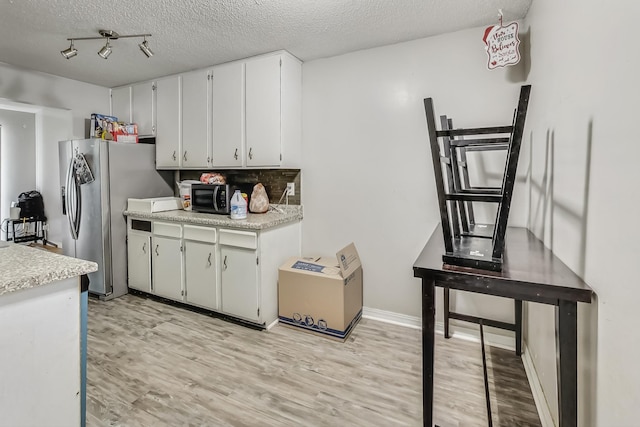 kitchen with stainless steel appliances, a textured ceiling, light hardwood / wood-style flooring, and white cabinets