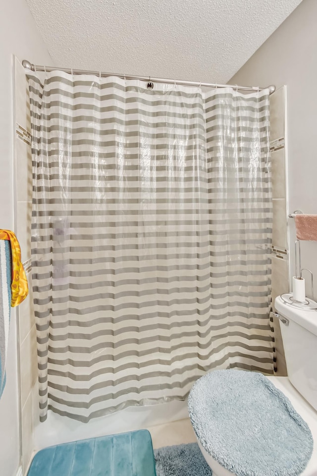 bathroom featuring toilet, tile patterned floors, a textured ceiling, and shower / bath combo with shower curtain