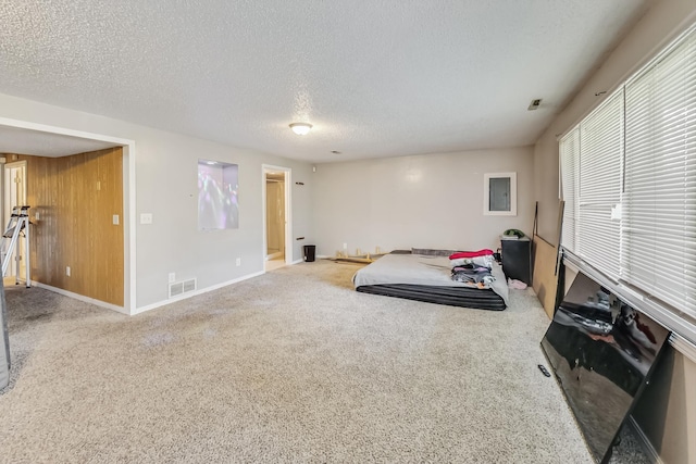 exercise area with carpet and a textured ceiling