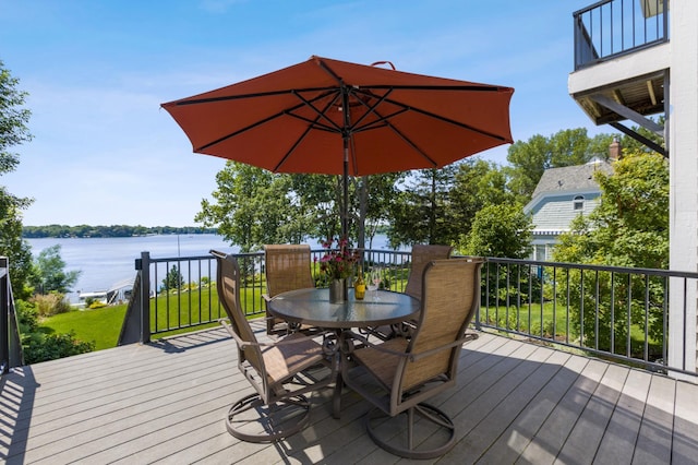 deck featuring outdoor dining space and a water view
