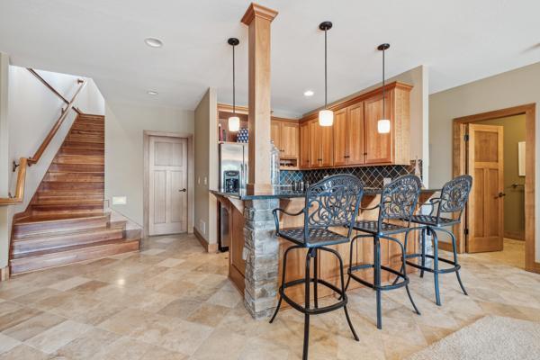 kitchen with dark countertops, a breakfast bar area, a peninsula, tasteful backsplash, and pendant lighting