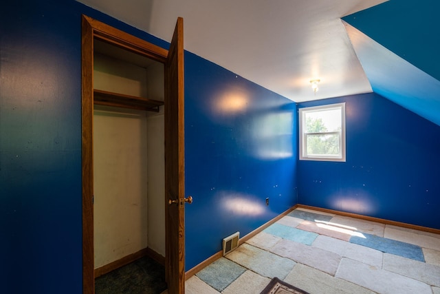 unfurnished bedroom featuring vaulted ceiling and a closet