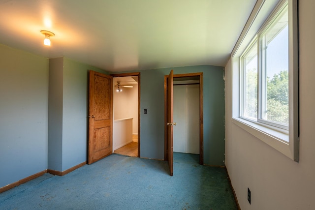 unfurnished bedroom featuring lofted ceiling, light carpet, and a closet