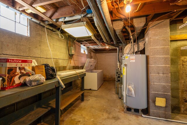 basement with refrigerator, water heater, and a wealth of natural light