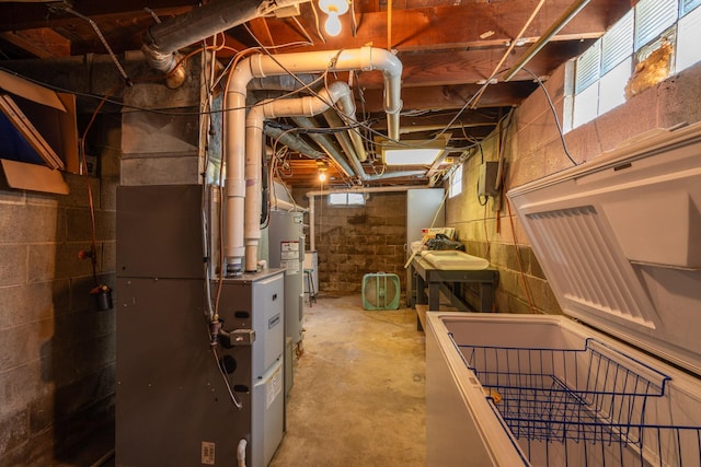 basement featuring sink, electric water heater, and heating unit