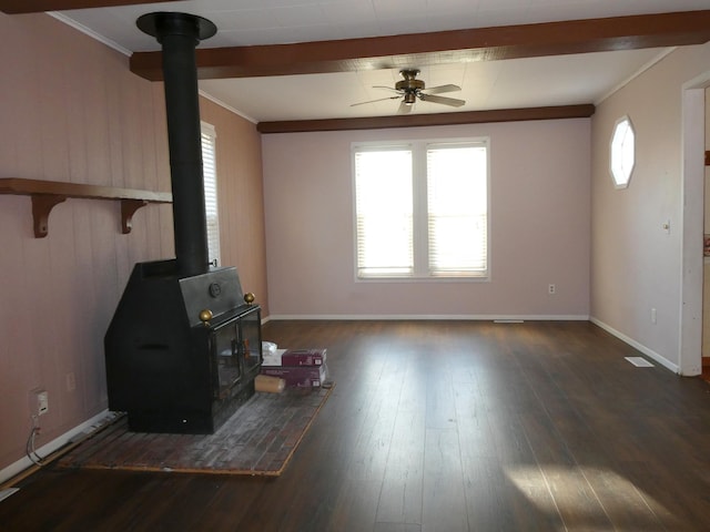 unfurnished living room with a wood stove, dark hardwood / wood-style flooring, ornamental molding, and ceiling fan