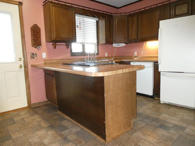 kitchen featuring kitchen peninsula, white appliances, dark tile patterned flooring, and ornamental molding