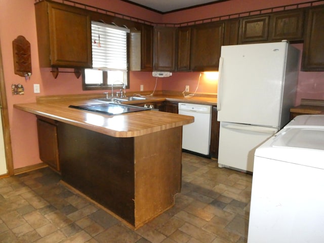 kitchen featuring sink, white appliances, dark tile patterned flooring, and kitchen peninsula