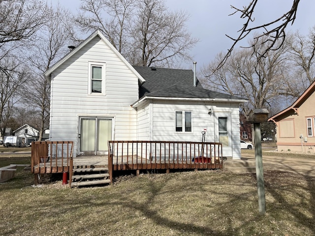 back of house with a wooden deck and a lawn