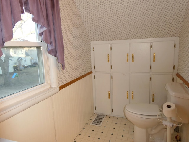 737 3rd Ave, Windom, MN 56101 - bathroom with toilet, tile patterned floors, wallpapered walls, and plenty of natural light