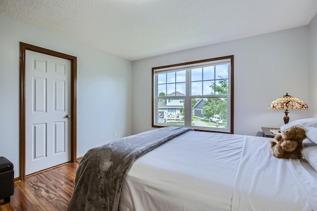 bedroom featuring wood-type flooring and a textured ceiling