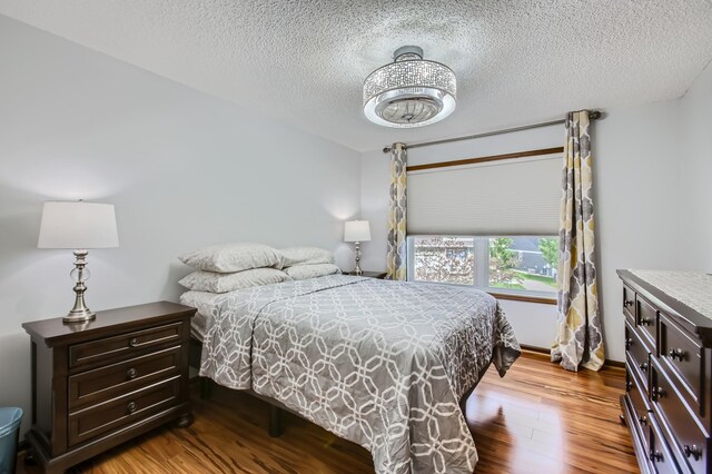 bedroom featuring a textured ceiling and light hardwood / wood-style flooring