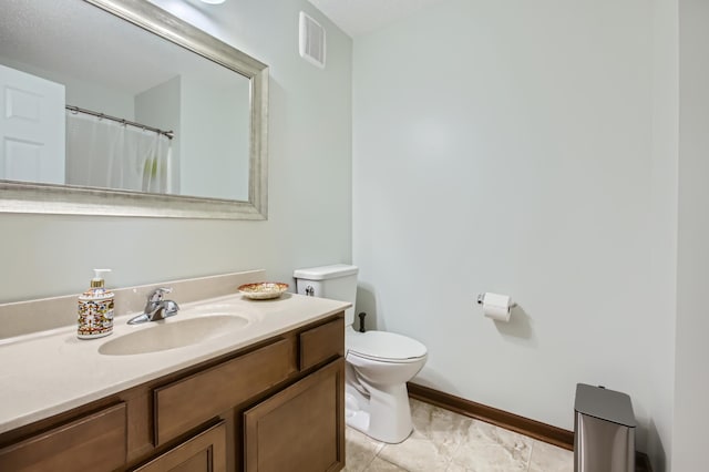 bathroom with tile patterned flooring, vanity, and toilet