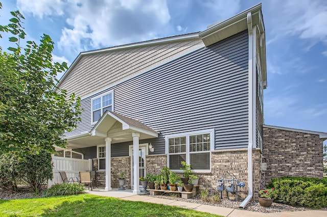 back of property with brick siding and fence