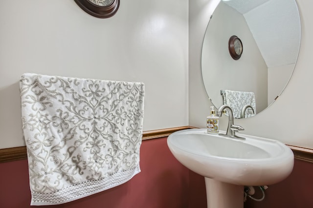 bathroom with vaulted ceiling and a sink