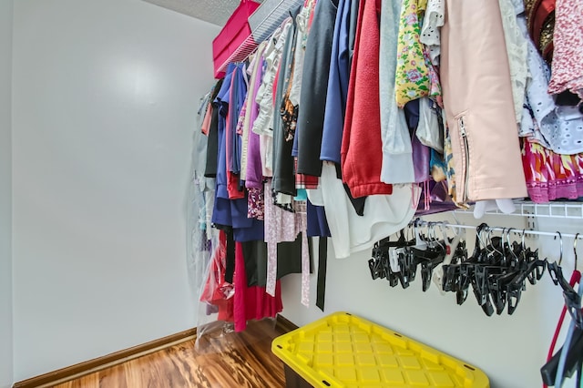 walk in closet with wood finished floors