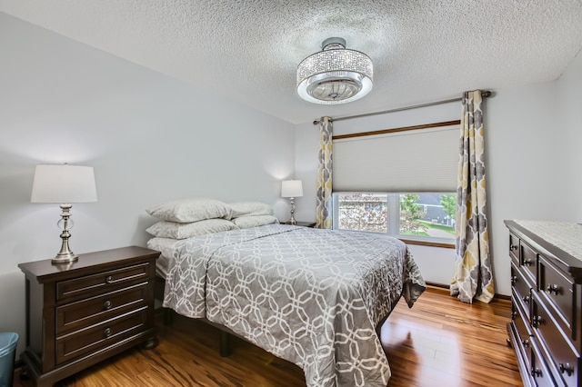 bedroom with a textured ceiling and dark wood-style flooring