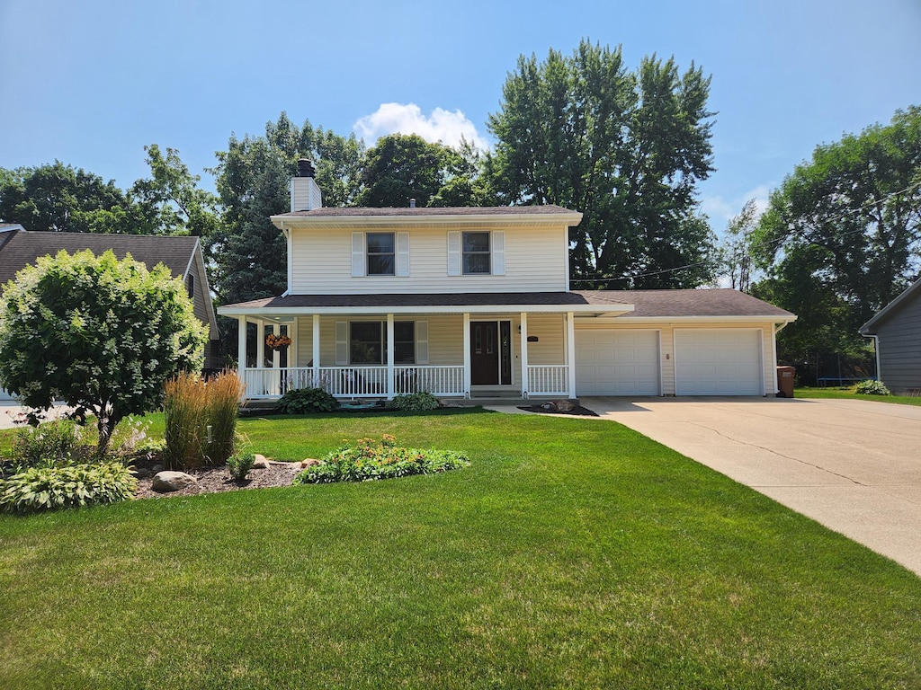 view of front facade featuring a garage, a front lawn, and a porch