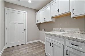 745 Hilltop Ln, Saint Croix Falls, WI 54024 - laundry room featuring baseboards, cabinet space, light wood-style flooring, and washer hookup