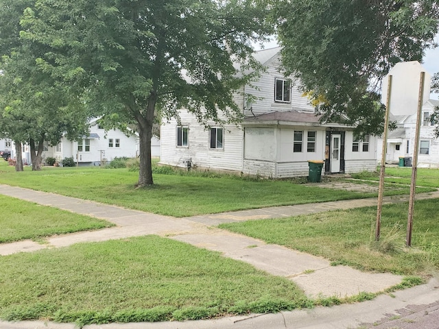 view of property hidden behind natural elements with a front lawn