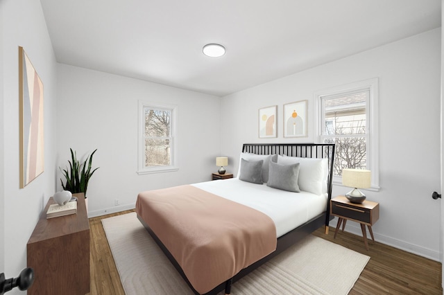 bedroom with baseboards and wood finished floors