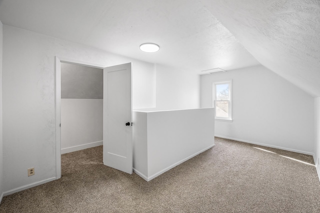 bonus room with a textured ceiling, baseboards, lofted ceiling, and carpet floors