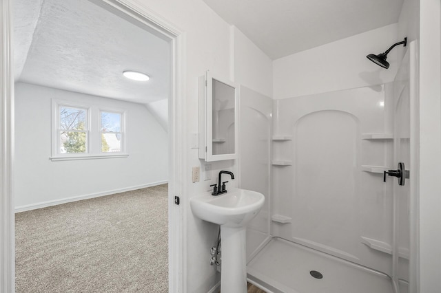 bathroom featuring baseboards, a textured ceiling, a stall shower, and vaulted ceiling