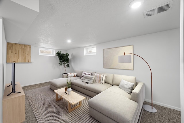 living area featuring a wealth of natural light, visible vents, and carpet floors