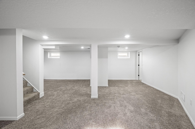 basement featuring baseboards, a textured ceiling, carpet floors, and stairs