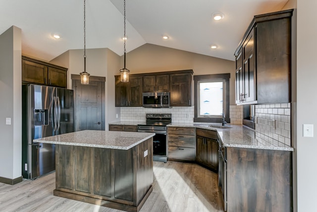 kitchen featuring hanging light fixtures, stainless steel appliances, light hardwood / wood-style flooring, lofted ceiling, and a kitchen island