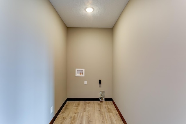 laundry room featuring hookup for a washing machine, a textured ceiling, and light hardwood / wood-style flooring