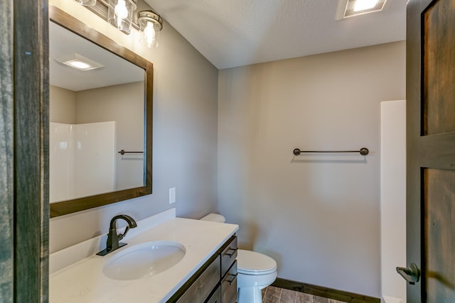 bathroom with hardwood / wood-style floors, vanity, a shower, toilet, and a textured ceiling