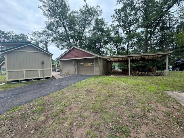 view of front of home featuring a carport, an outdoor structure, a garage, and a front yard