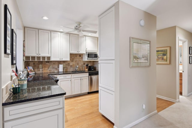 kitchen featuring sink, ceiling fan, appliances with stainless steel finishes, white cabinets, and decorative backsplash