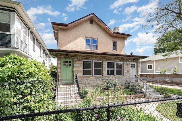 view of front facade with stucco siding, a chimney, fence, and stone siding