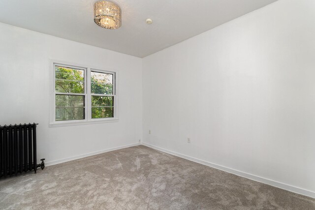 carpeted empty room featuring radiator