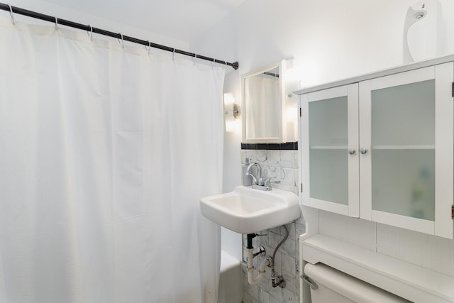 full bathroom with backsplash, tile walls, toilet, and sink