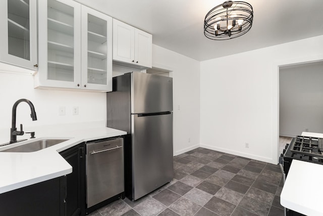 kitchen featuring stainless steel appliances, white cabinetry, an inviting chandelier, and sink