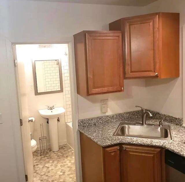 kitchen with sink, stainless steel dishwasher, and light tile patterned floors