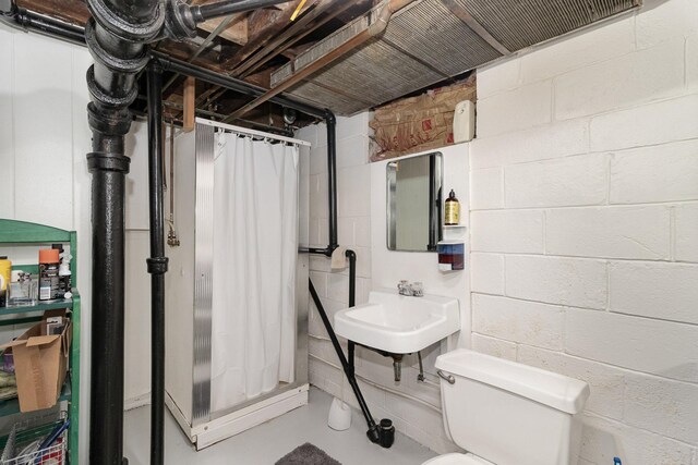 bathroom featuring sink, walk in shower, and toilet