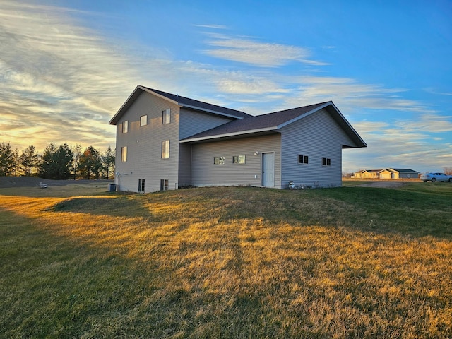 property exterior at dusk with a lawn