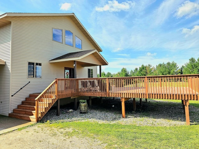 back of house with a deck and a lawn