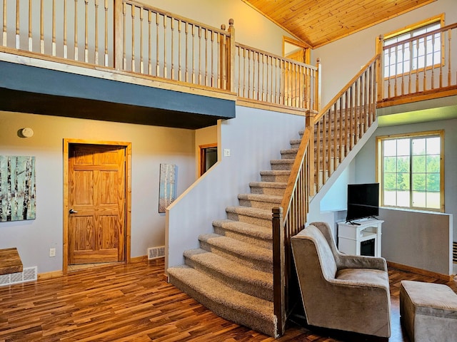 stairway with high vaulted ceiling, wood-type flooring, and wood ceiling