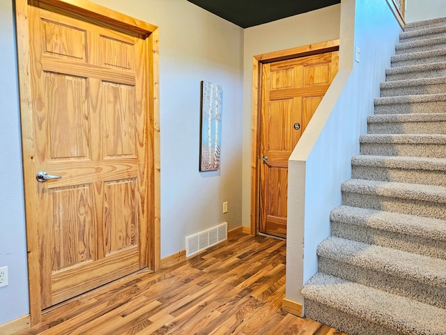 staircase with hardwood / wood-style floors