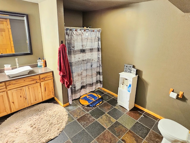 bathroom with toilet, vanity, and walk in shower