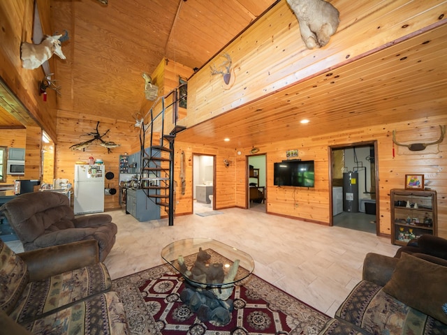 tiled living room with a towering ceiling, wood ceiling, wooden walls, and water heater