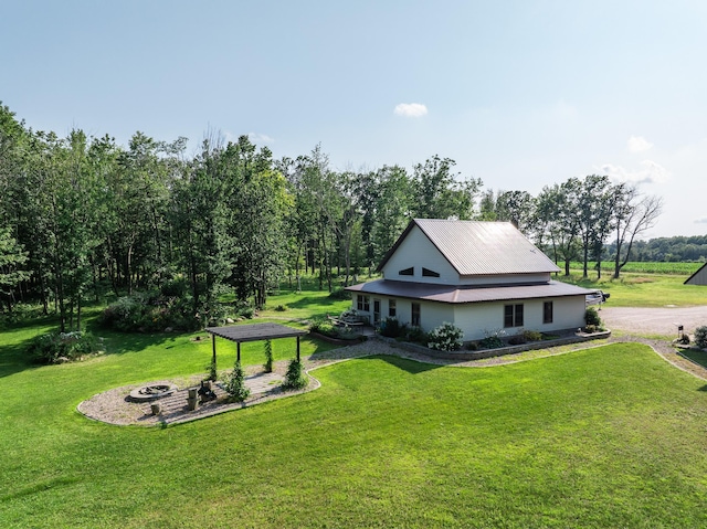 exterior space featuring an outdoor fire pit and a front lawn