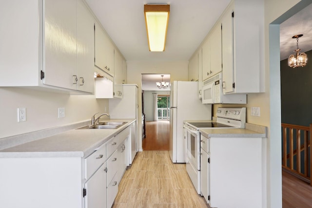 kitchen featuring white cabinets, sink, white appliances, and an inviting chandelier