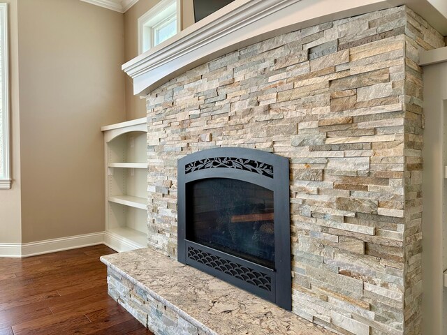 1225 Dorothy St, Isle, MN 56342 - detailed view of baseboards, ornamental molding, wood finished floors, a stone fireplace, and built in shelves