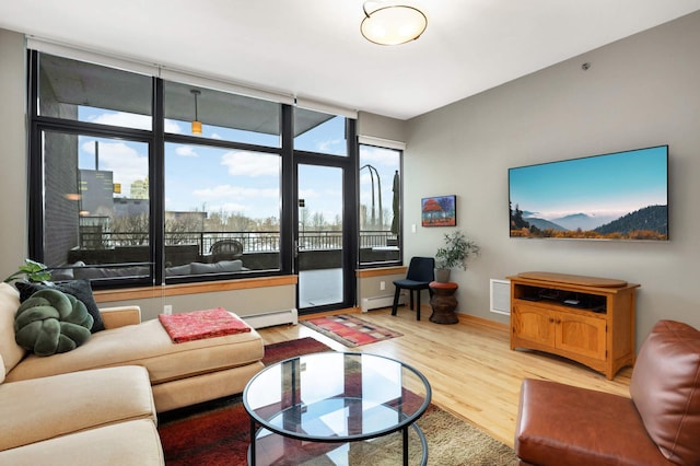 living room with baseboard heating, a healthy amount of sunlight, and wood-type flooring